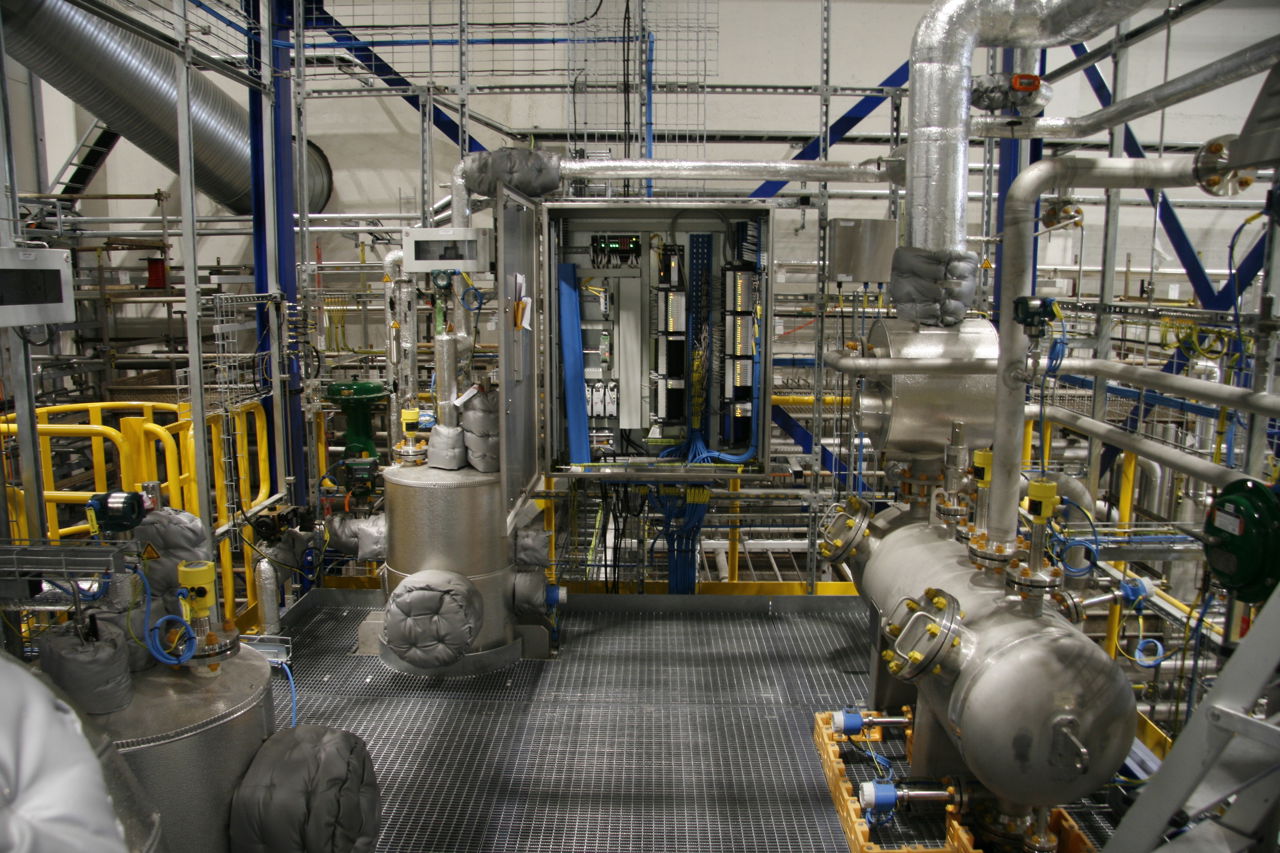 Rør og maskiner på innsiden av en fabrikk